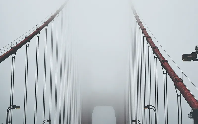 A suspension bridge running into cloud