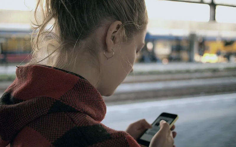 Someone checking a phone on a station platform
